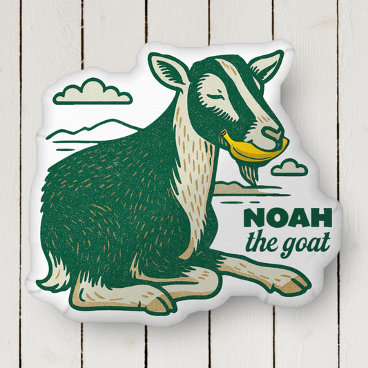 NOAH THE GOAT EATING A BANANA SHAPED PILLOW